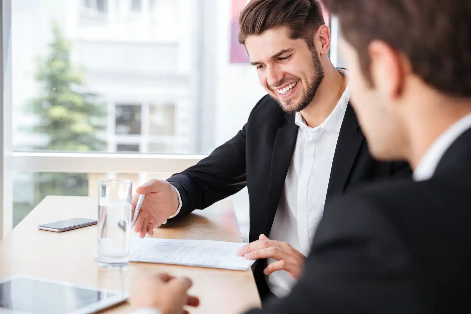 Smiling PRO specialist reviewing payment information with a client after performing a GDRFA fine check.